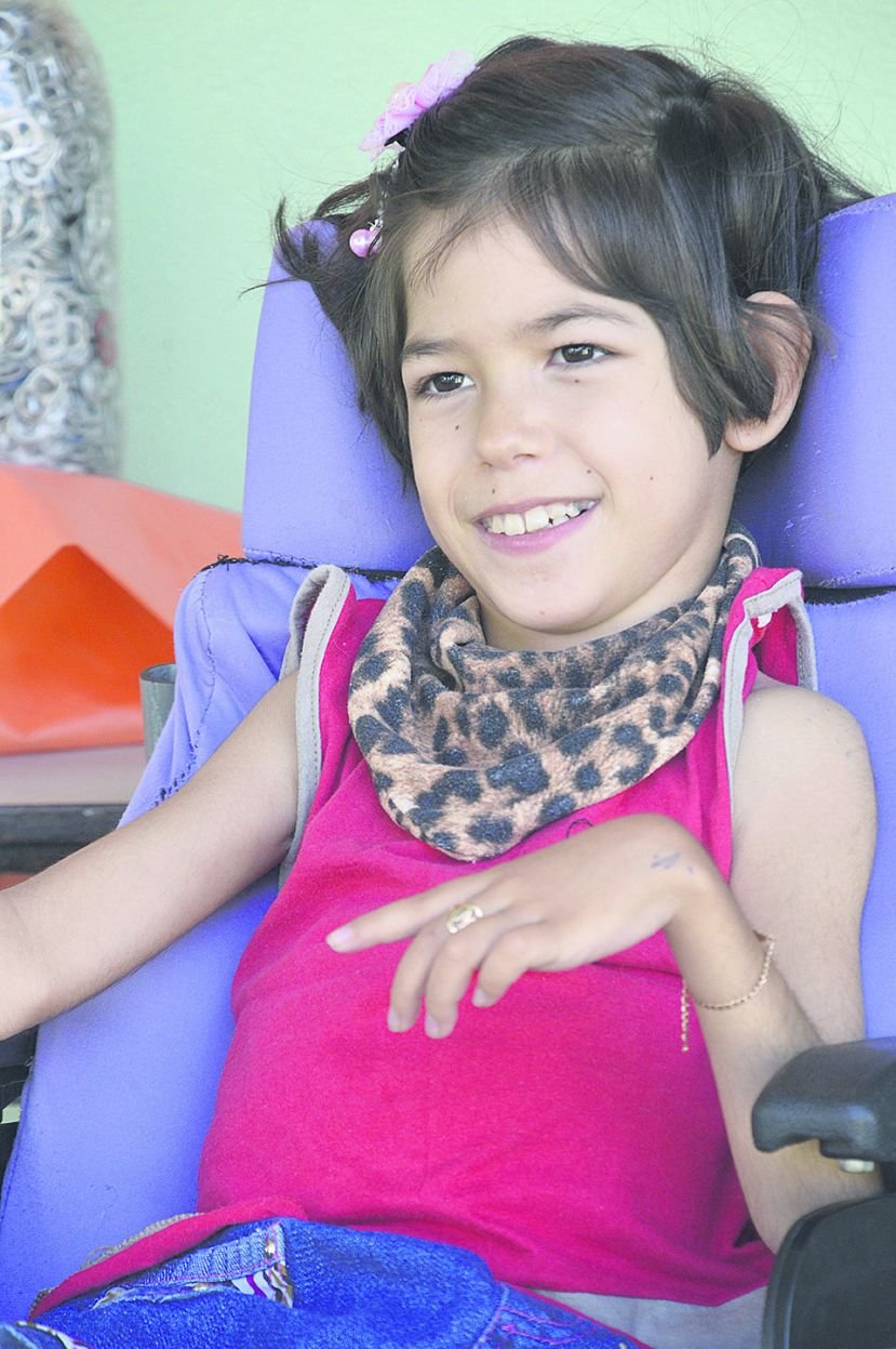 Menina de 8 anos busca recursos para adquirir cadeira de rodas para continuar se locomovendo